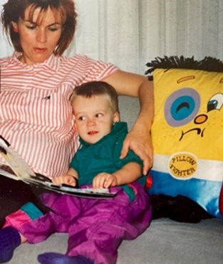 A young mother and a toddler read a tactile book together.